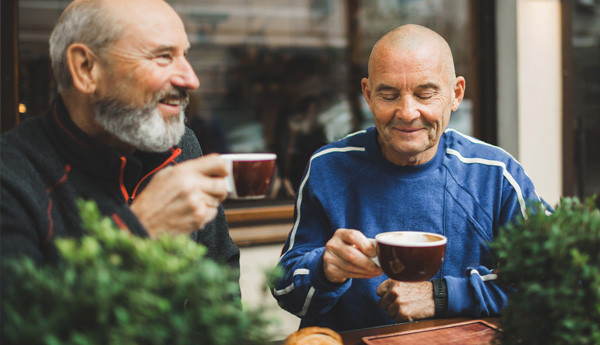 Two men enjoying lattes.