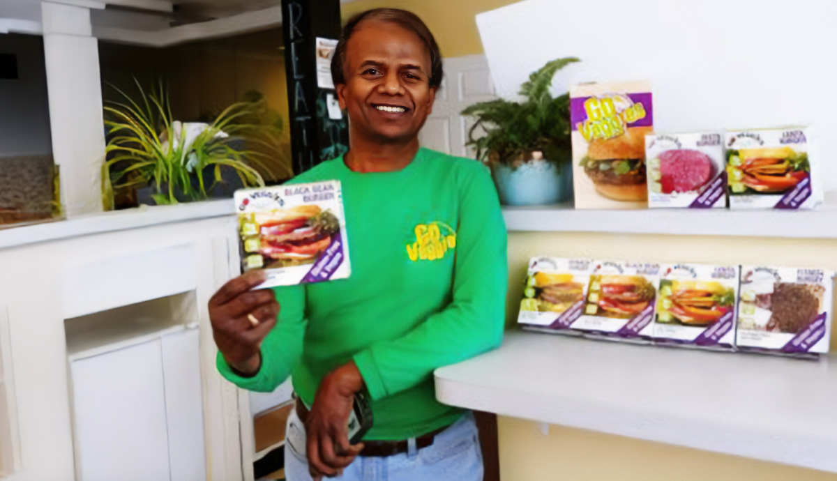 Man smiling and holding up a product he developed.