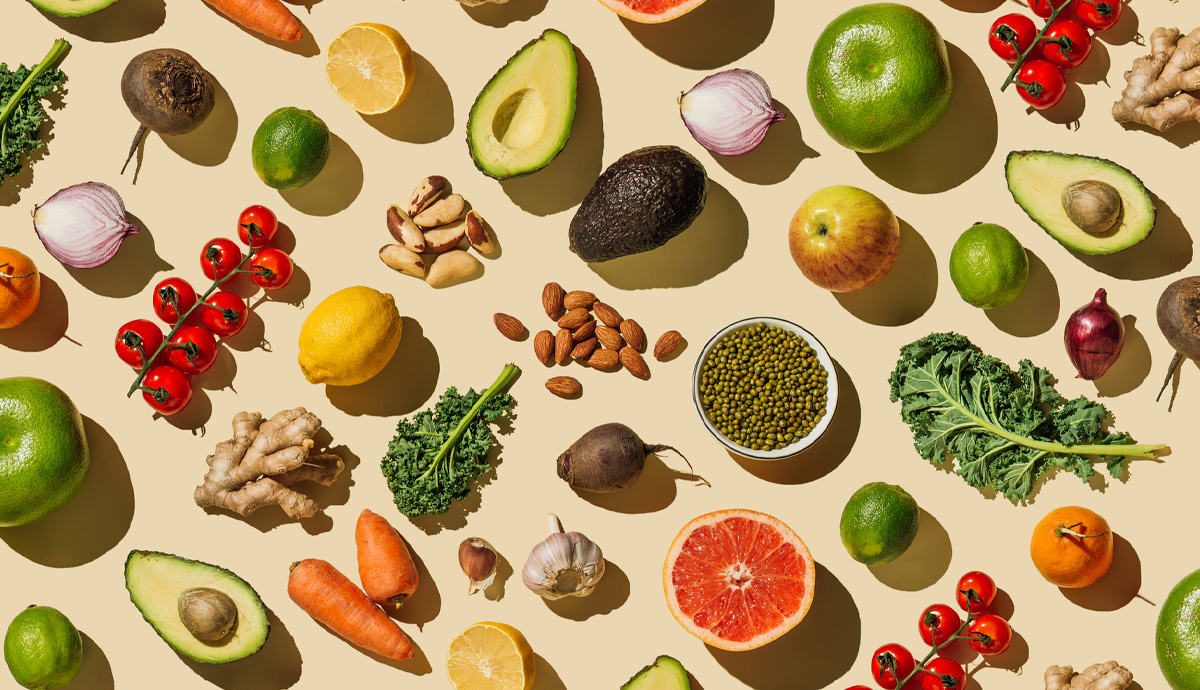 A pattern of various fresh fruits and vegetables on a beige background.