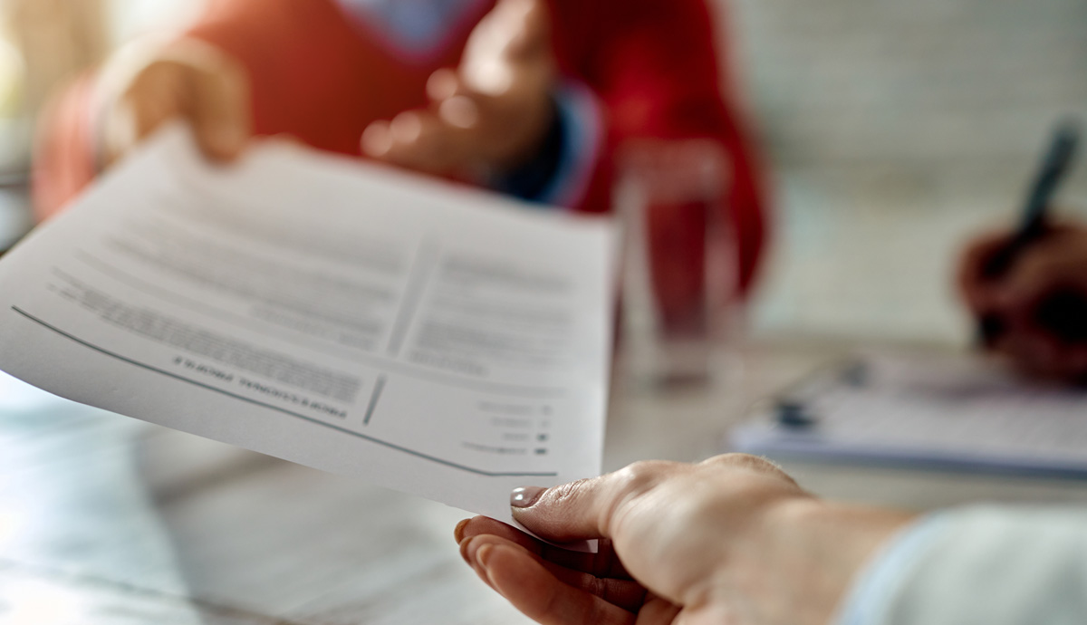 A person handing their resume to an interviewer