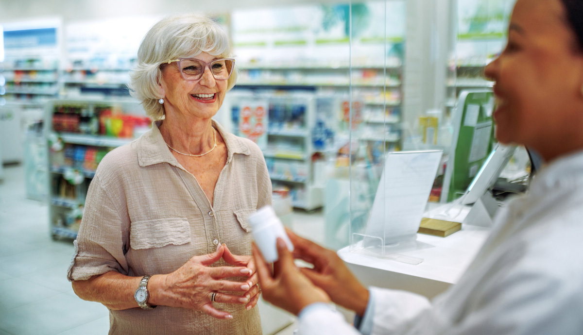 Image of a woman smiling at the pharmacy counter