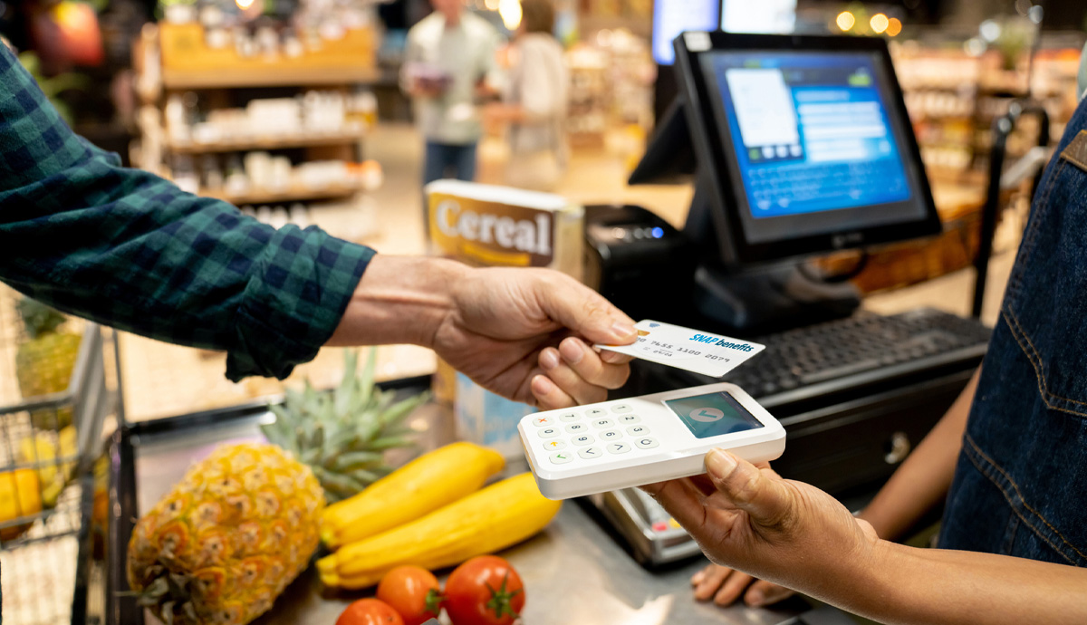 Image of a person scanning their card at a grocery store