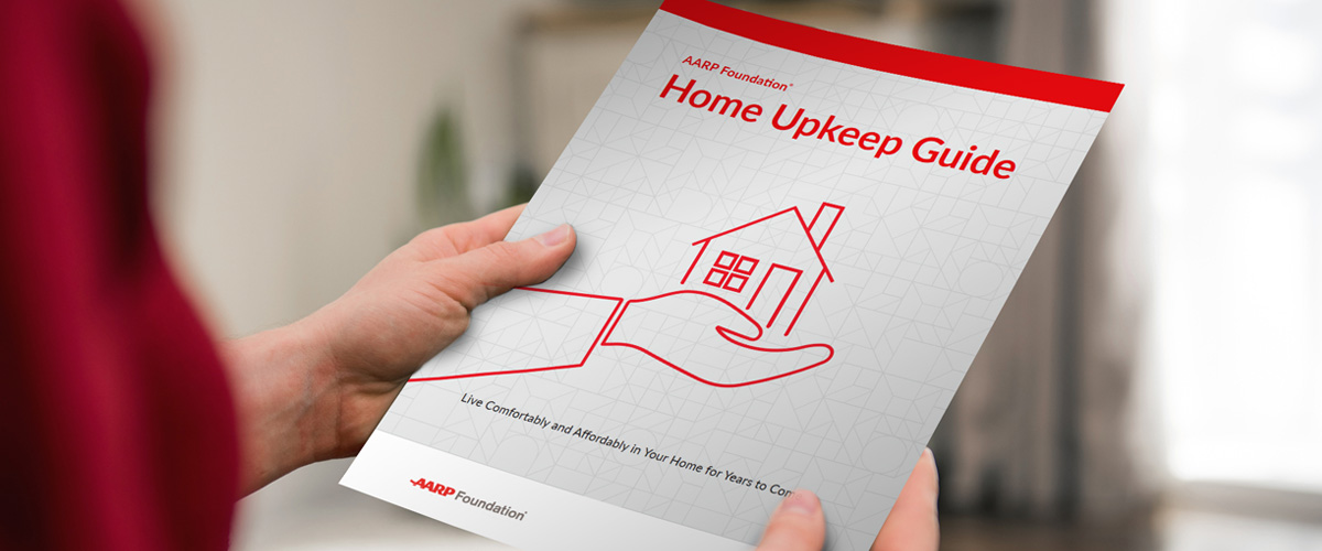 Person holding a printed-out copy of the Home Upkeep Guide