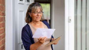 Woman standing at her front door looking at a tax bill