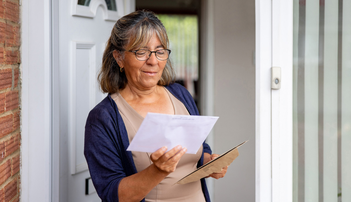 Woman standing at her front door looking at a tax bill