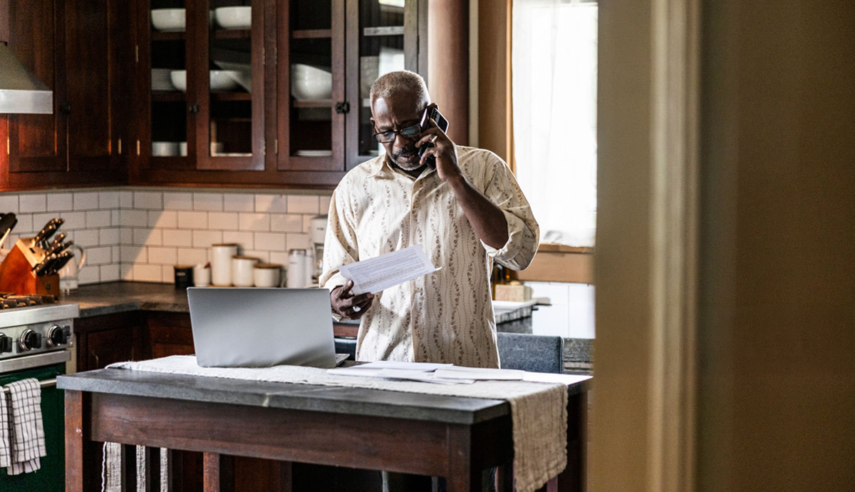A man looks concerned while talking on the phone